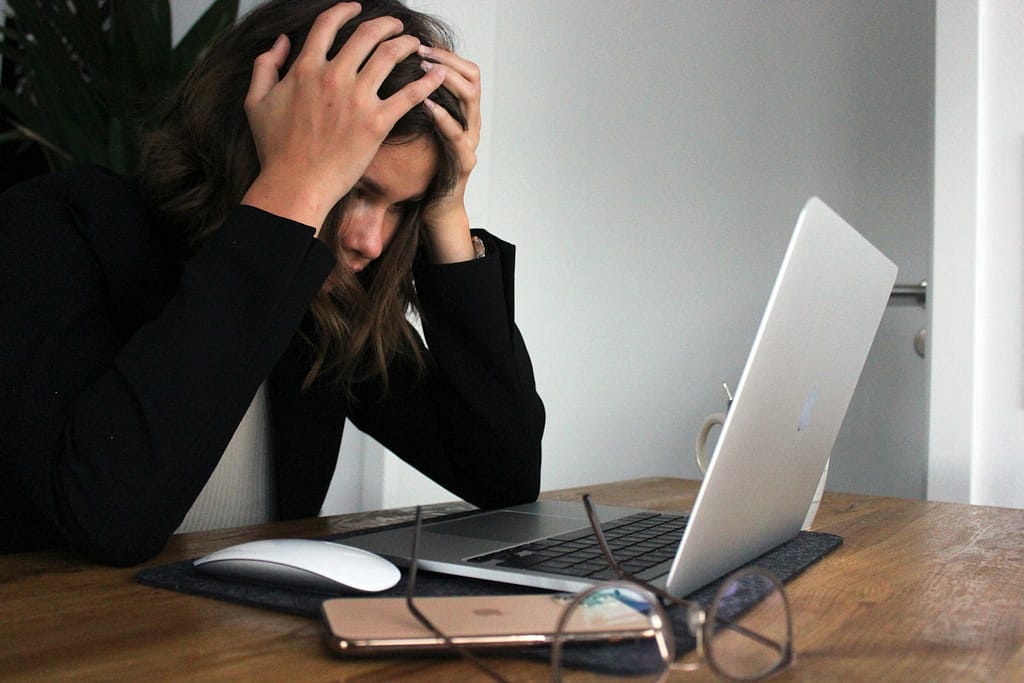 a woman sitting in front of a laptop computer - arrêter de subir son business