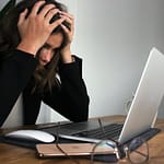 a woman sitting in front of a laptop computer