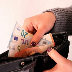 a woman is holding a wallet full of money