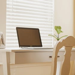 a laptop computer sitting on top of a wooden desk