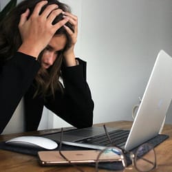 a woman sitting in front of a laptop computer